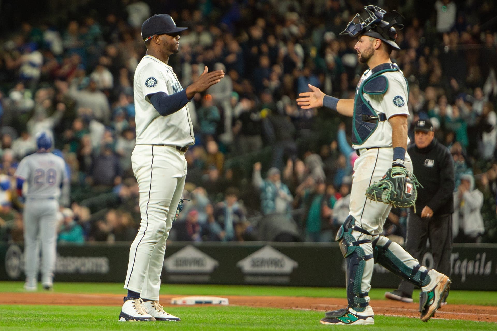 Mariners pitcher and catcher meeting between the mound and home plate