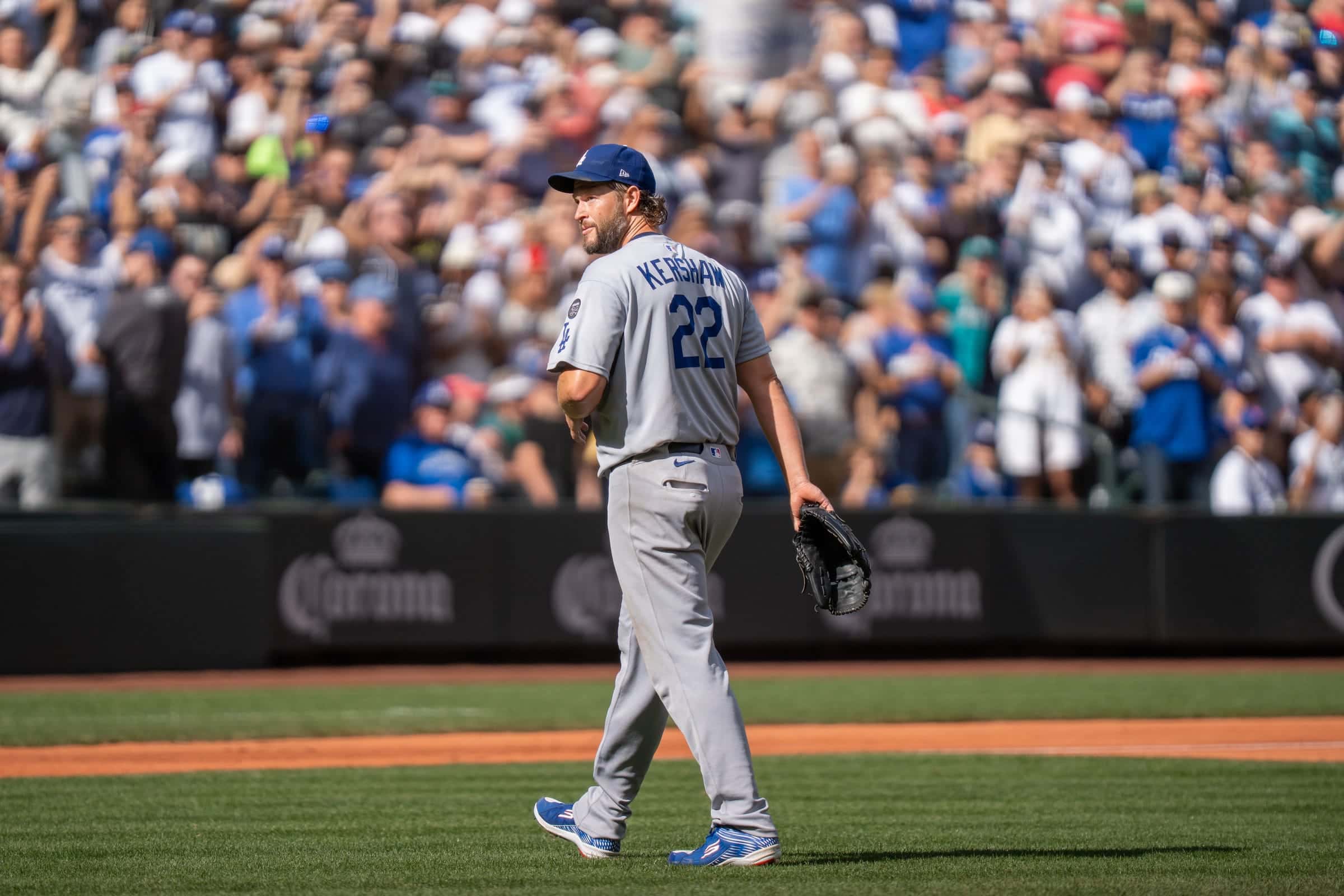 Dodgers pitcher Clayton Kershaw, number 22, walking off the field as the crowd stands and applauds
