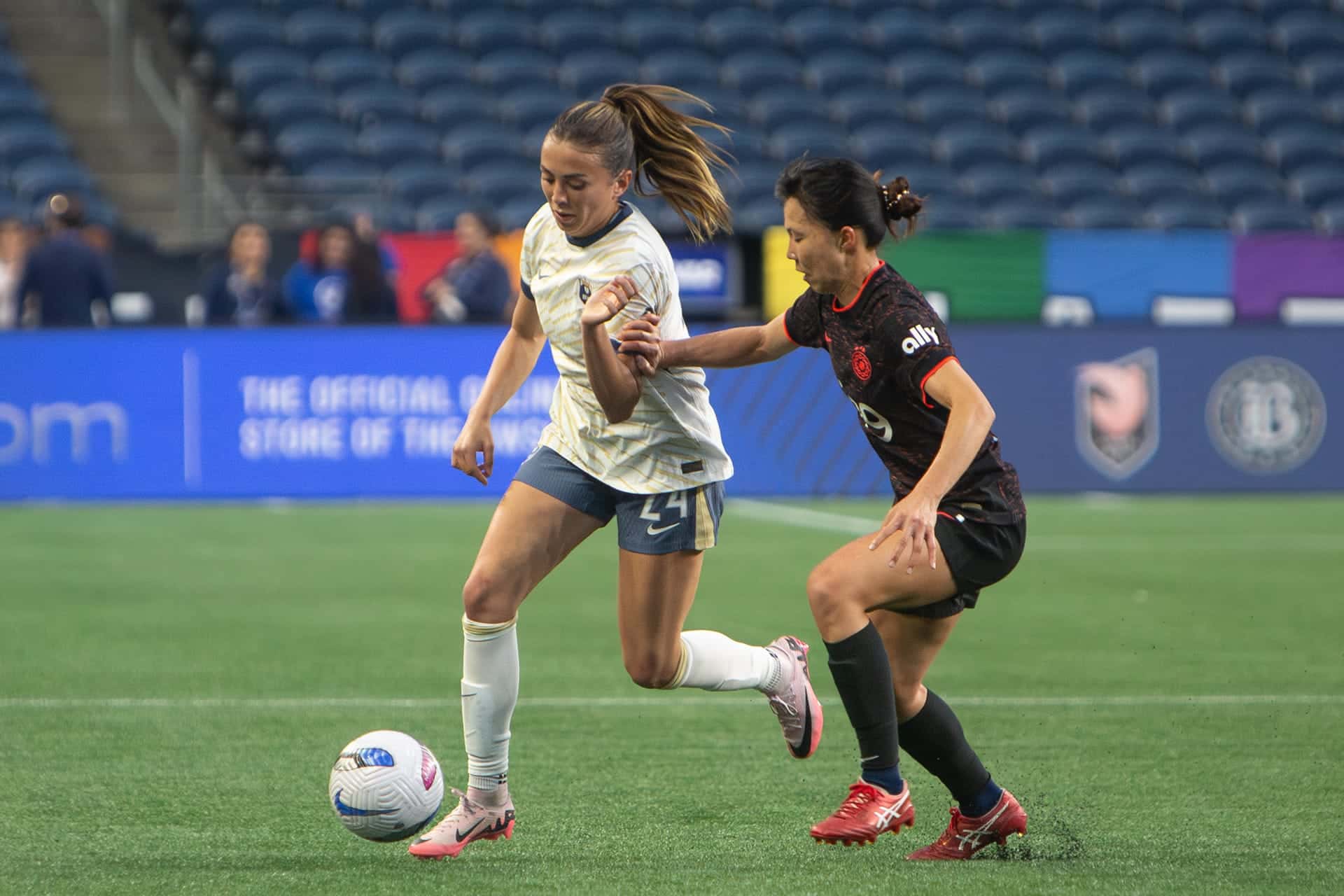 Reign player shielding the ball from a defender while dribbling along the sideline