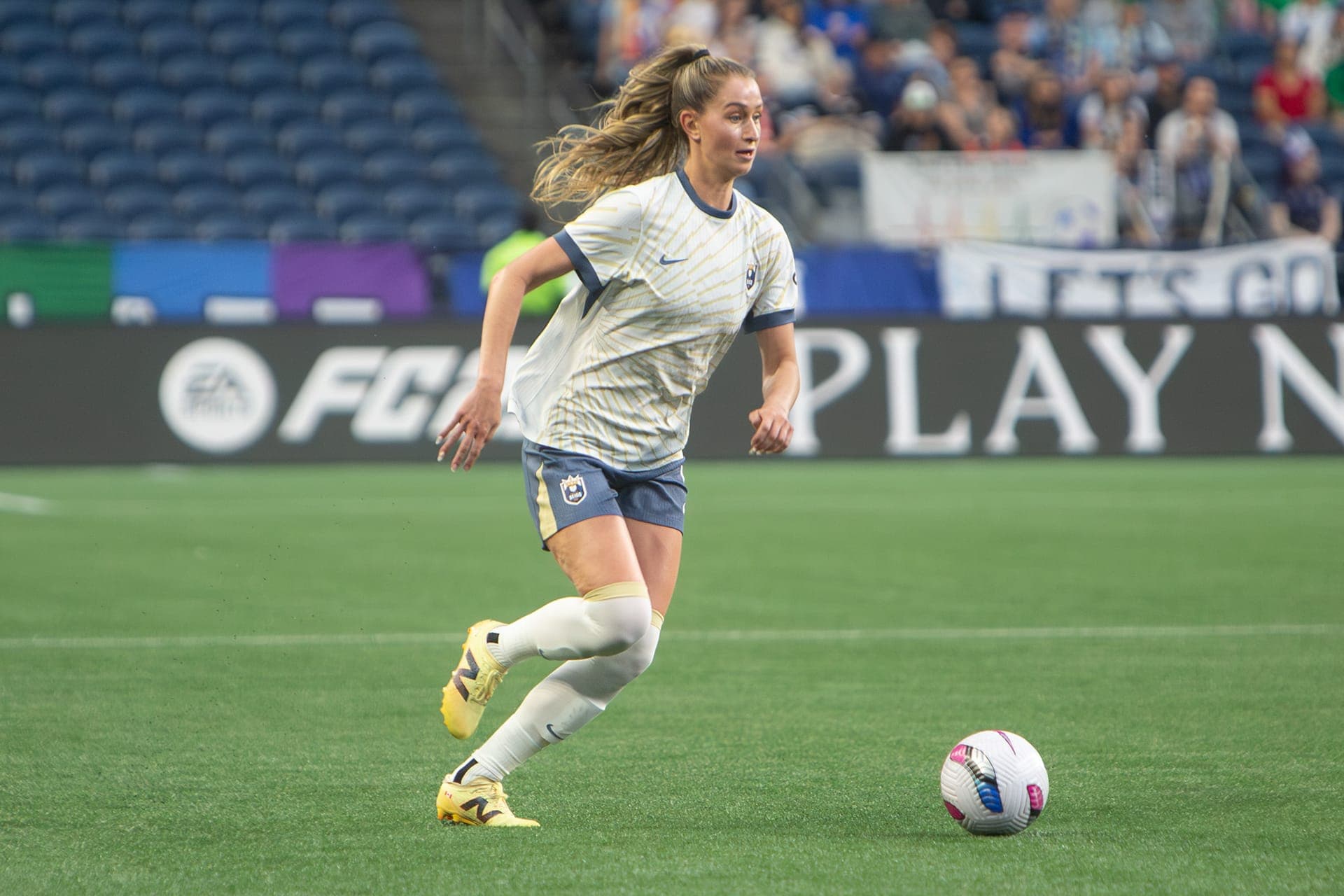 Reign player pushing the ball forward with her eyes up