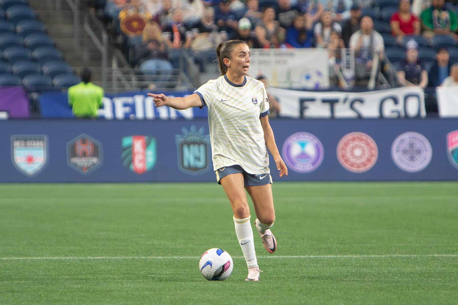 Reign player controlling the ball near the sideline boards