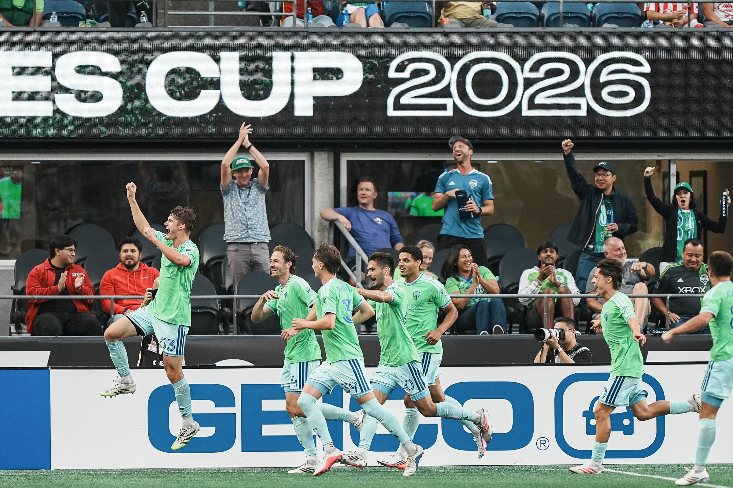 Sounders players sprinting to celebrate a goal as fans cheer under a Leagues Cup 2026 banner