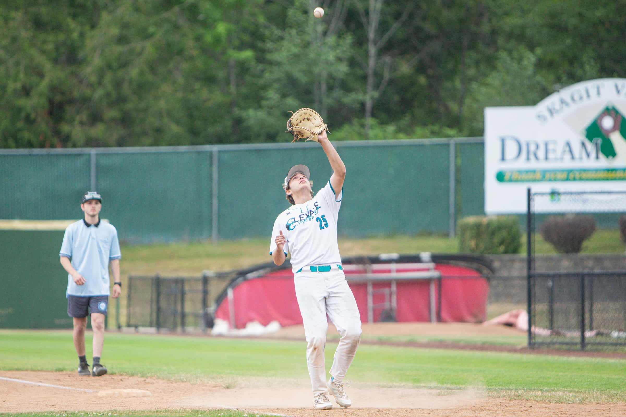 Infielder settling under a pop fly beside the Dream Field sign