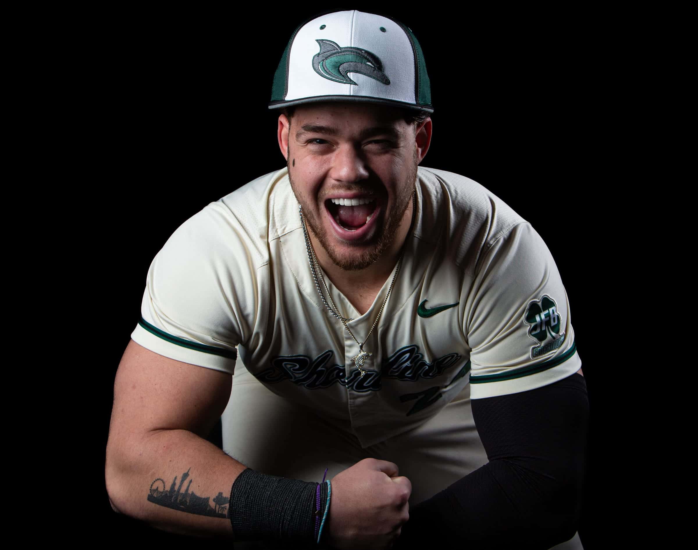 Shoreline player laughing and flexing toward the camera on a black backdrop