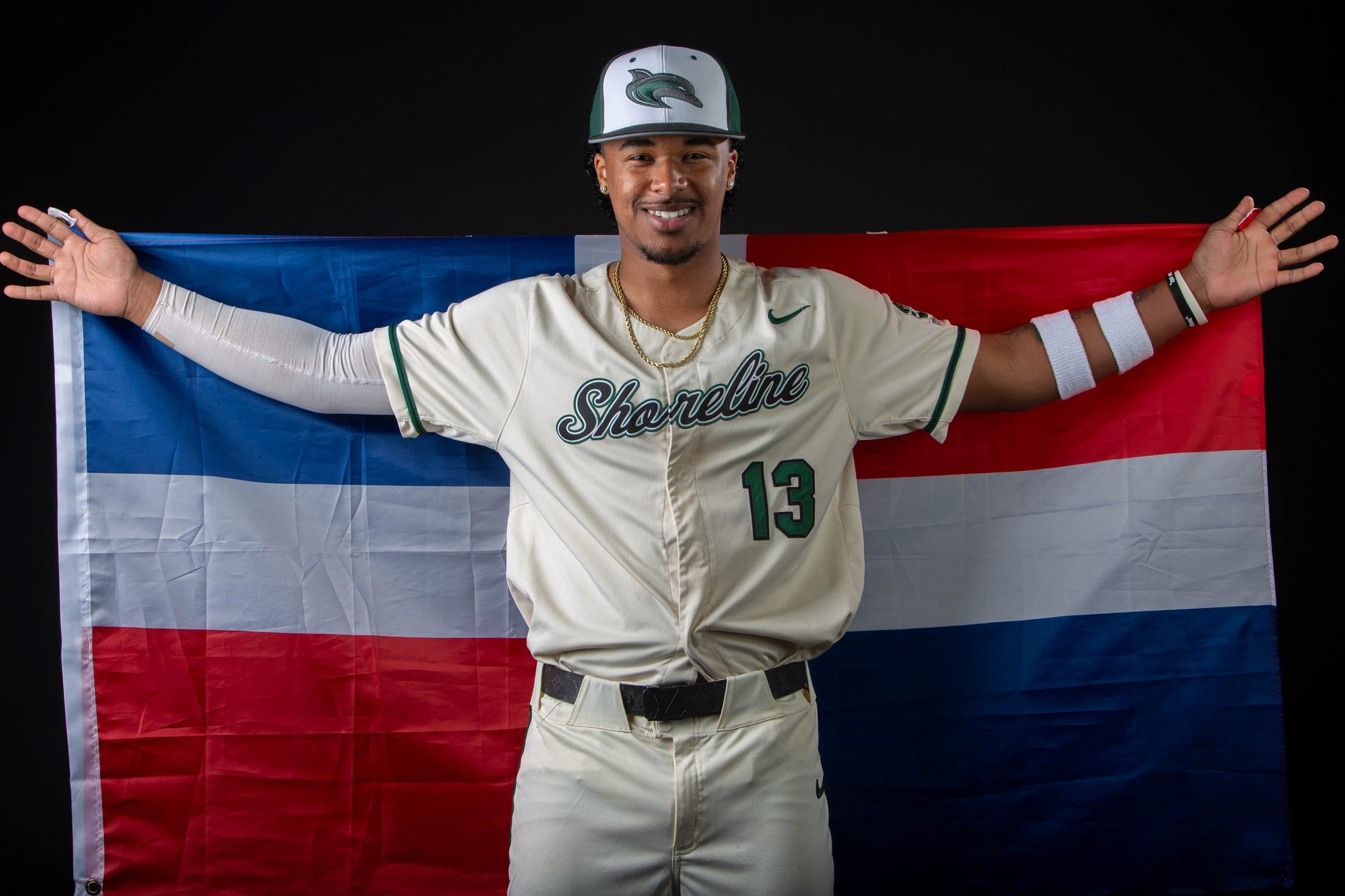 Shoreline player holding a Dominican Republic flag behind him with his arms spread