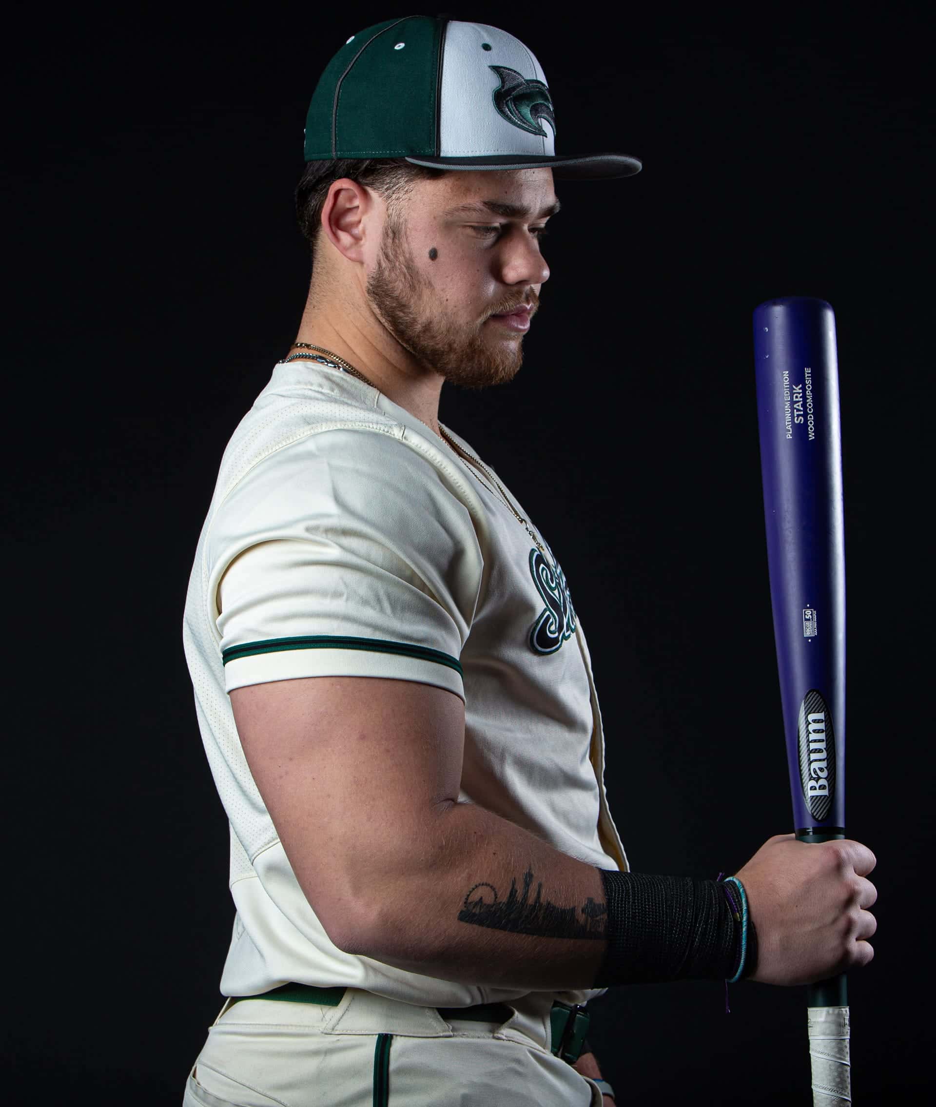 Shoreline player holding a bat at his side in profile