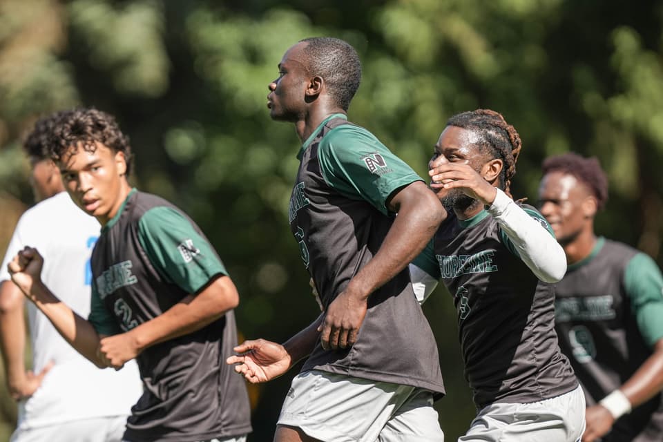 Shoreline men’s soccer players running upfield together, one pumping his fist